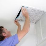 Man servicing air conditioning unit for Great Day Plumbing & Air, showcasing HVAC maintenance expertise.