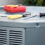 Air conditioning unit with tools like yellow-handled pliers and a screwdriver, Great Day Plumbing & Air maintenance work.