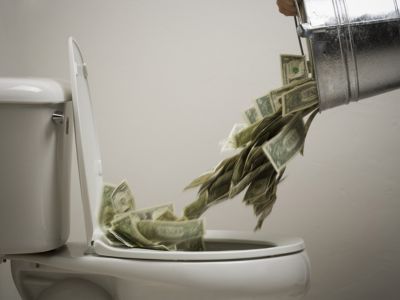 Toilet overflowing with cash, illustrating the financial impact of plumbing issues like slab leaks, emphasizing the importance of timely repairs.