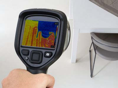 Thermal imaging device detecting heat signatures to locate slab leaks under a home foundation.