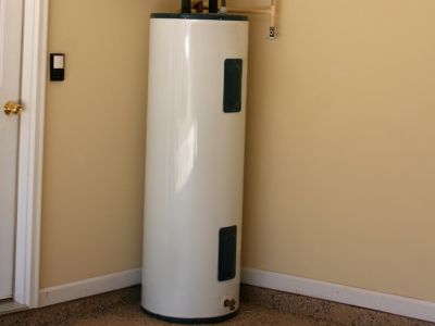 Gas water heater installed in a home setting, showcasing a tall, cylindrical design with visible plumbing connections, emphasizing efficient heating solutions for homeowners.